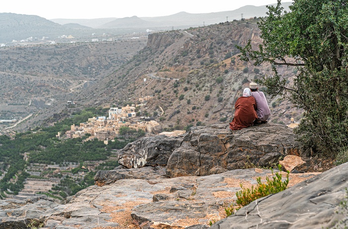Lokale kigger ud over dal med en landsby i Oman