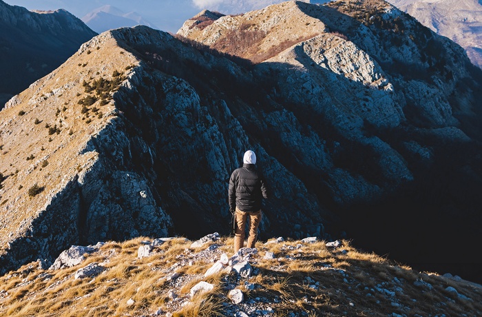 Mandelig turist ser ud over bjergene i Lovćen National Park i Montenegro