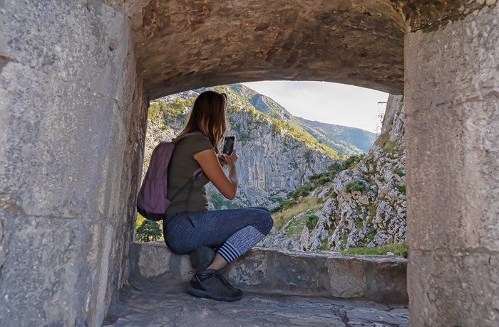 Kvindelig turist tager billeder i Lovćen National Park i Montenegro