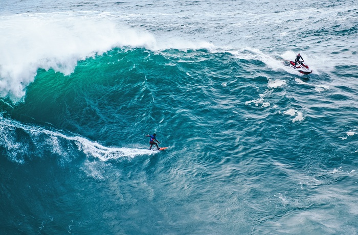 Surfer på kæmpe bølge ud for Nazare, Portugal