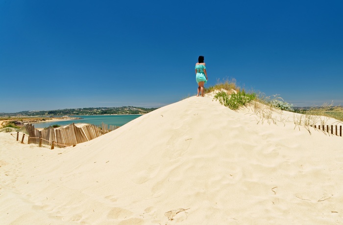 Kvinde nyder udsigten mod naturreservatet Ria de Alvor, Portugal