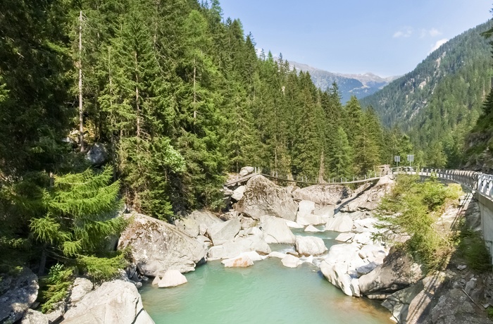En hængebro i baggrunden over flod i kløften Viamala i Schweiz