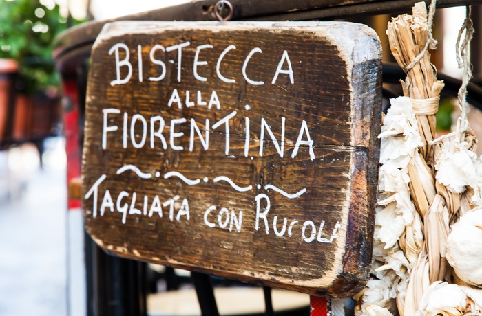 Skilt til restaurant med Bistecca alla Fiorentina - kæmpe bøf fra Firenze og Toscana