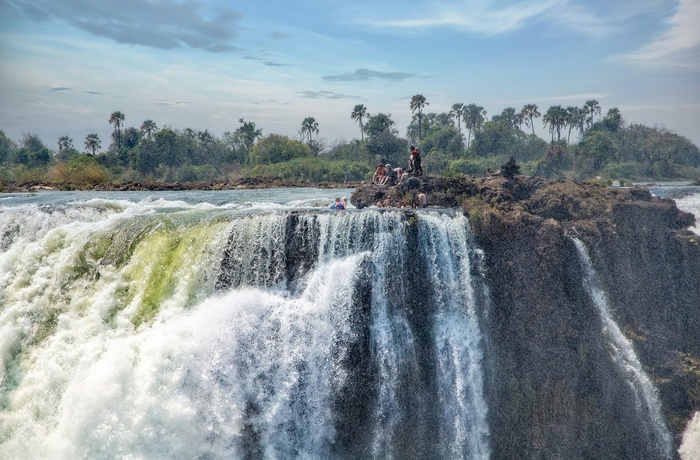 Turister med guide på kanten af Victoria Falls i Zimbabwe - Foto: Vince Russell, Unsplash