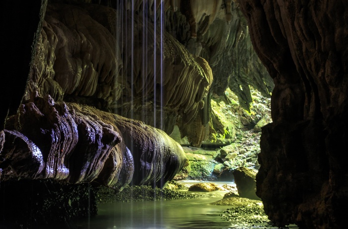 Vandfald foran grotte i Waitomo, nordøen i New Zealand