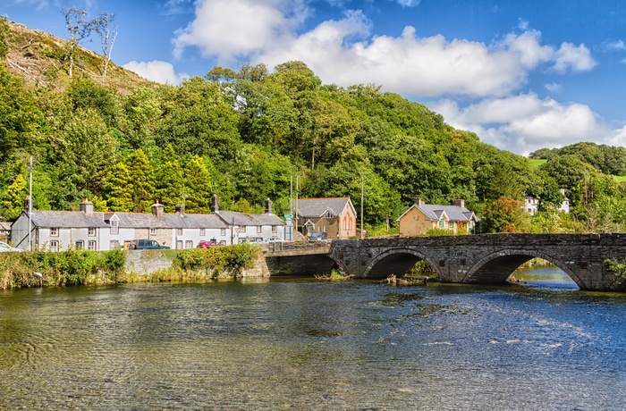Små huse og en gammel bro over en flod i Snowdonia National Park, Wales