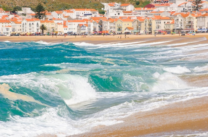 Strand og bølger ved feriebyen Nazare, Portugal