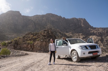 4WD og rejsende på grusvej på Jebel Sharm i Al Hajar-bjergene - Oman