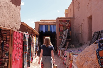 Kvindelig turist på vej gennem Ait Ben Haddou - ikoniske lerby mellem Atlasbjergene og ørkenen i Marokko