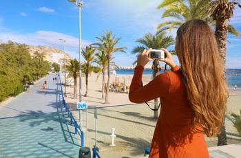 Ung kvinde tager billede af stranden Playa del Postiguet i Alicante