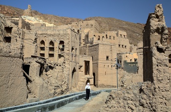 inde går langs Falaj vandingssystemet i Birkat Al Mouz - ruinby i Oman