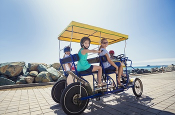 Familie på cykeltur langs kysten i Californien