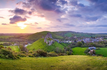  Corfe Castle og slotsruinen i solnedgang, Dorset i Sydengland