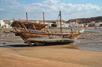 Gammel dhow på stranden i kystbyen Sur i Oman