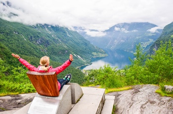 Kvinde nyder udsigten til Geirangerfjorden fra Queen Sony Stolen ved Flydalsjuvet, Norge