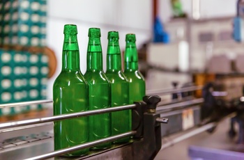 Glasflasker med cider uden etiketter på aftapningslinje