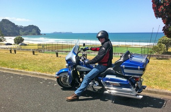 På Harley Davidson motorcykel ved strand i New Zealand