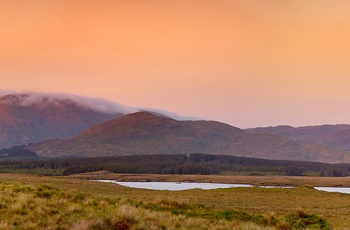 Orangerødt aftenlys over landskabet i Connemara, Vestirland