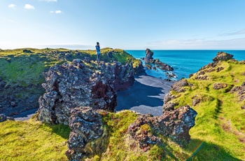 Hiker ser ned på Djúpalónssandur sorte strand på Snæfellsnes halvøen, Island