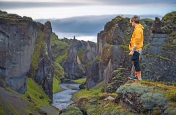 Hiker og udsigt til Fjaðrárgljúfur kløften og floden Fjaðrá , Island