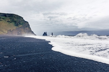 Reynisfjara stranden med det sorte sand og klipperne Reynisdrangar, Island