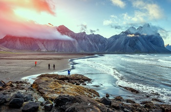 Turister på strand med udsigt til Vestrahorn bjerget på Stokksnes halvøen, Island