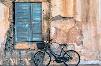 Cykel foran en gammel, smuk facade i kystbyen Itea - Grækenland