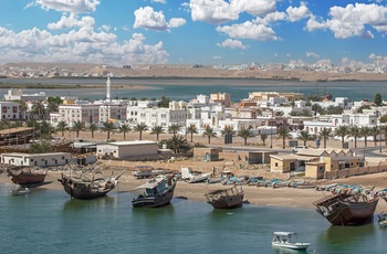 Traditionelle dhower træskibe ved stranden i kystbyen Sur i Oman