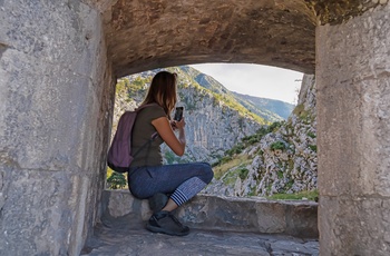 Kvindelig turist tager billeder i Lovćen National Park i Montenegro