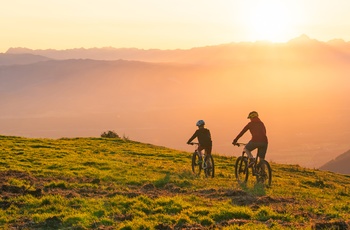 På mountainbike i solnedgang og udsigt til bølgende bakker