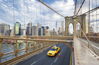 Gul taxi kører på Brooklyn Bridge i New York, USA