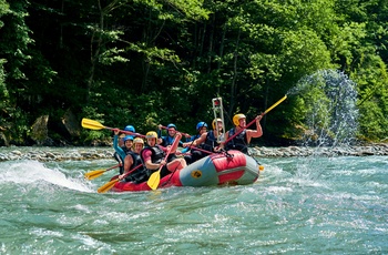Gruppe på raftingtur ned ad flod med små rapids