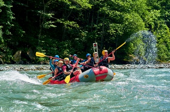 Gruppe på raftingtur ned ad flod med små rapids