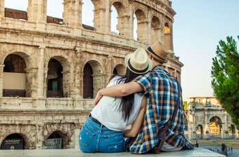 Ungt par foran Colosseum i Rom, Italien
