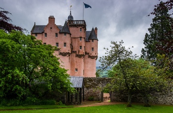 Skotland, Aberdeenshire, Alford - det karakteristiske lyserøde Craigievar Castle gemt bag parkens store træer