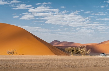 Bil parkeret ved en af de enorme sandklitter i Sossusvlei, Namib-Naukluft National Park, Namibia