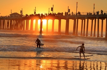 Surfere i solnedgang på Huntington Beach