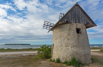 Gammel vindmølle på Ekstakustens kyststrækning og øen Stora Karlso i baggrunden, Gotland i Sverige