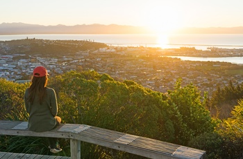 Kvinde nyder udsigte mod Nelson i solnedgang - Sydøen i New Zealand