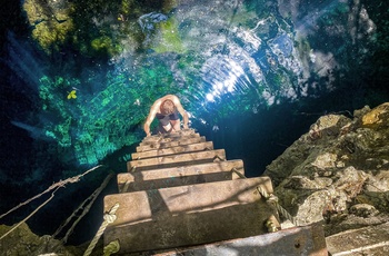 Turist på vej op af en cenote eller ferskvandshul på Yucatan-halvøen - Mexico