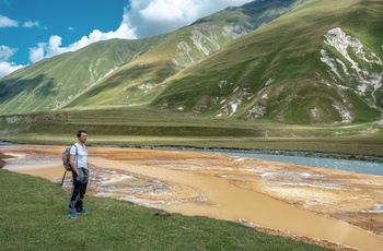 Turist ved orange travertinterrasse i Truso-dalen - Georgien
