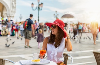 Ung kvinde ved cafebord på Markuspladsen i Venedig