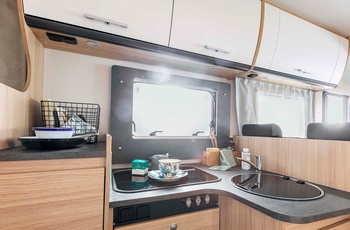 Helintegreret autocamper i Europa - eksempel på lille vinkelkøkken med gasblus og vask