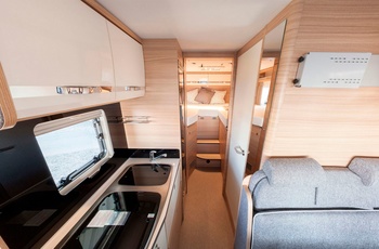 Helintegreret autocamper i Europa - siddegruppe, køkken og mellemgang til soveværelset