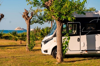 Helintegreret autocamper i Europa - klassisk model på campingplads ved vandet